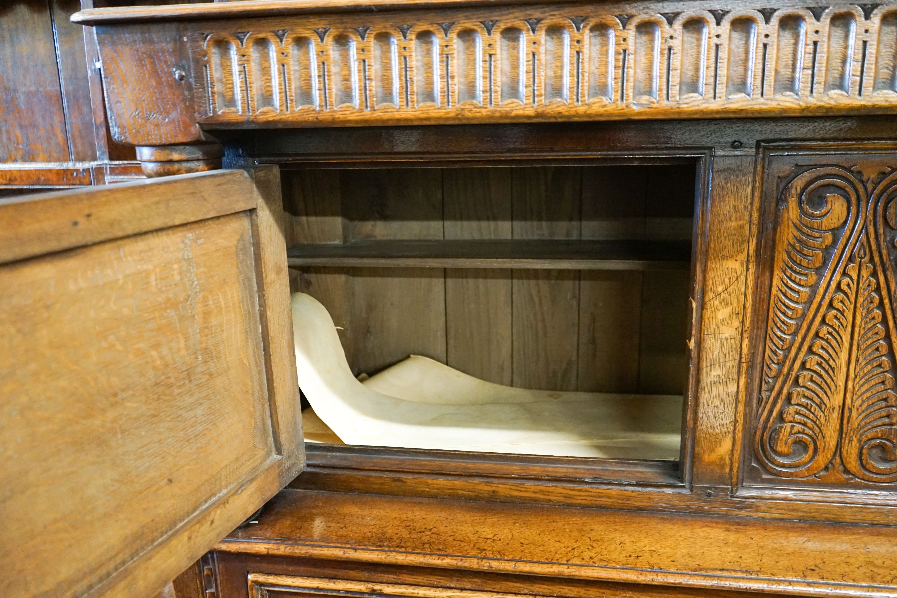 A 17th century style carved and panelled oak court cupboard